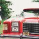A happy couple strolls past a classic red Ford LTD, a perfect ride for a 21st birthday celebration.