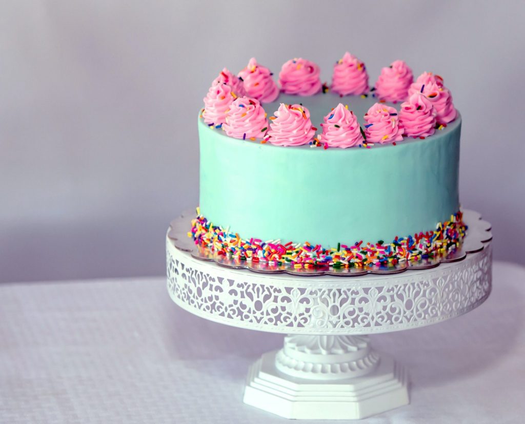 a bright pink and turquoise sweet 16 birthday cake 