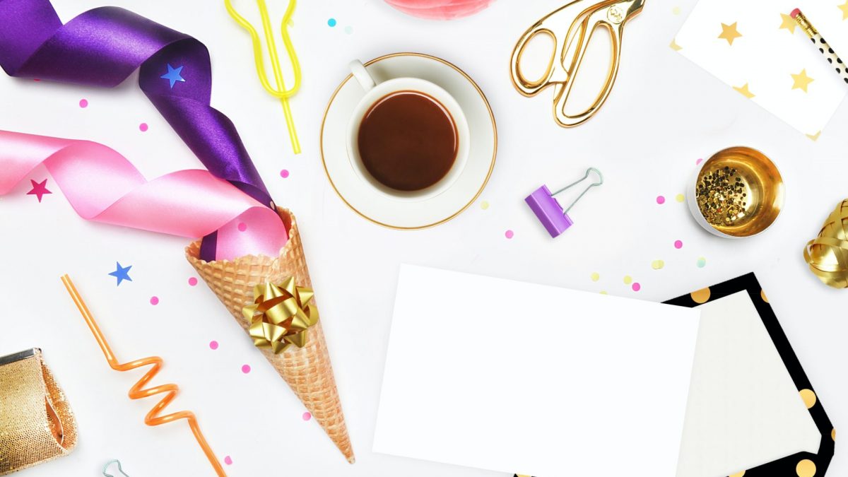 Flatlay of party supplies: ribbons, confetti, coffee, card, and envelope. Perfect for Sweet 16 party planning!