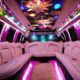 Pink party limo interior with colorful ceiling and LED lighting. Perfect for an unforgettable 2024 birthday celebration with bergenlimo.com.