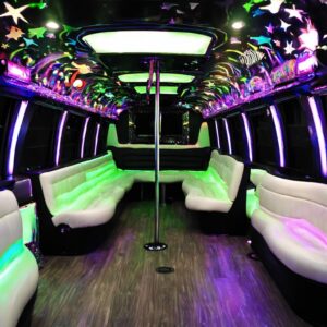Luxury party bus interior with white leather seating, colorful LED lighting, and a dance pole. Perfect for NJ nightlife!