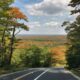 Scenic autumn road winding through colorful New Jersey forest.