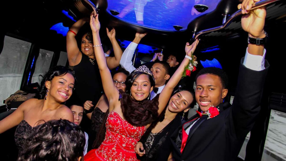 Excited teens celebrate in a Bergen Limo party bus, perfect for a Quinceañera.