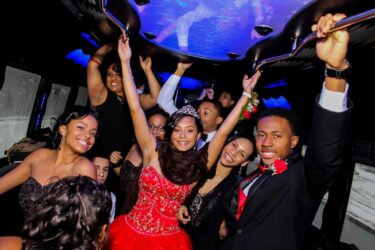 Excited teens celebrate in a Bergen Limo party bus, perfect for a Quinceañera.
