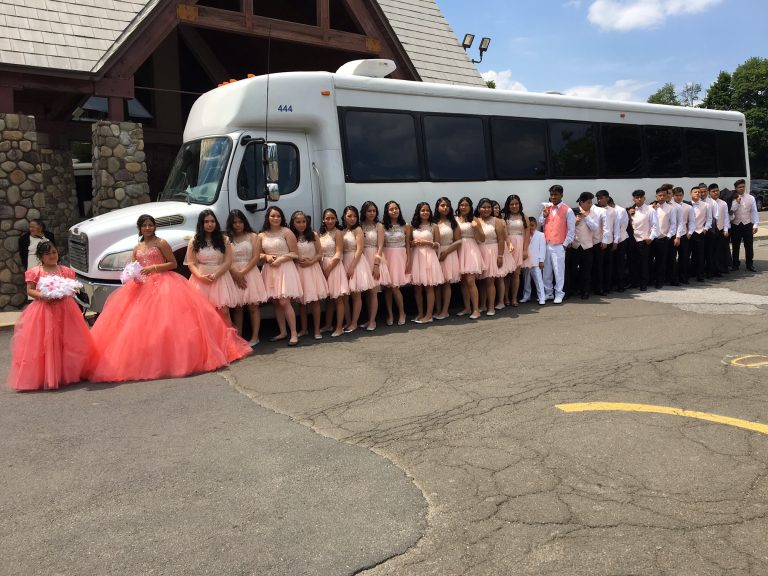 Group of Quinceañera attendees posing by a Bergen Limo party bus.