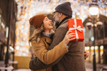 Romantic couple exchanging gifts on a snowy winter night in NJ.