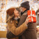 Romantic couple exchanging gifts on a snowy winter night in NJ.
