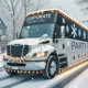 A festive party bus decorated for a corporate winter event drives through a snowy town. The bus reads "Party Bus" and "Corporate Winter Event.
