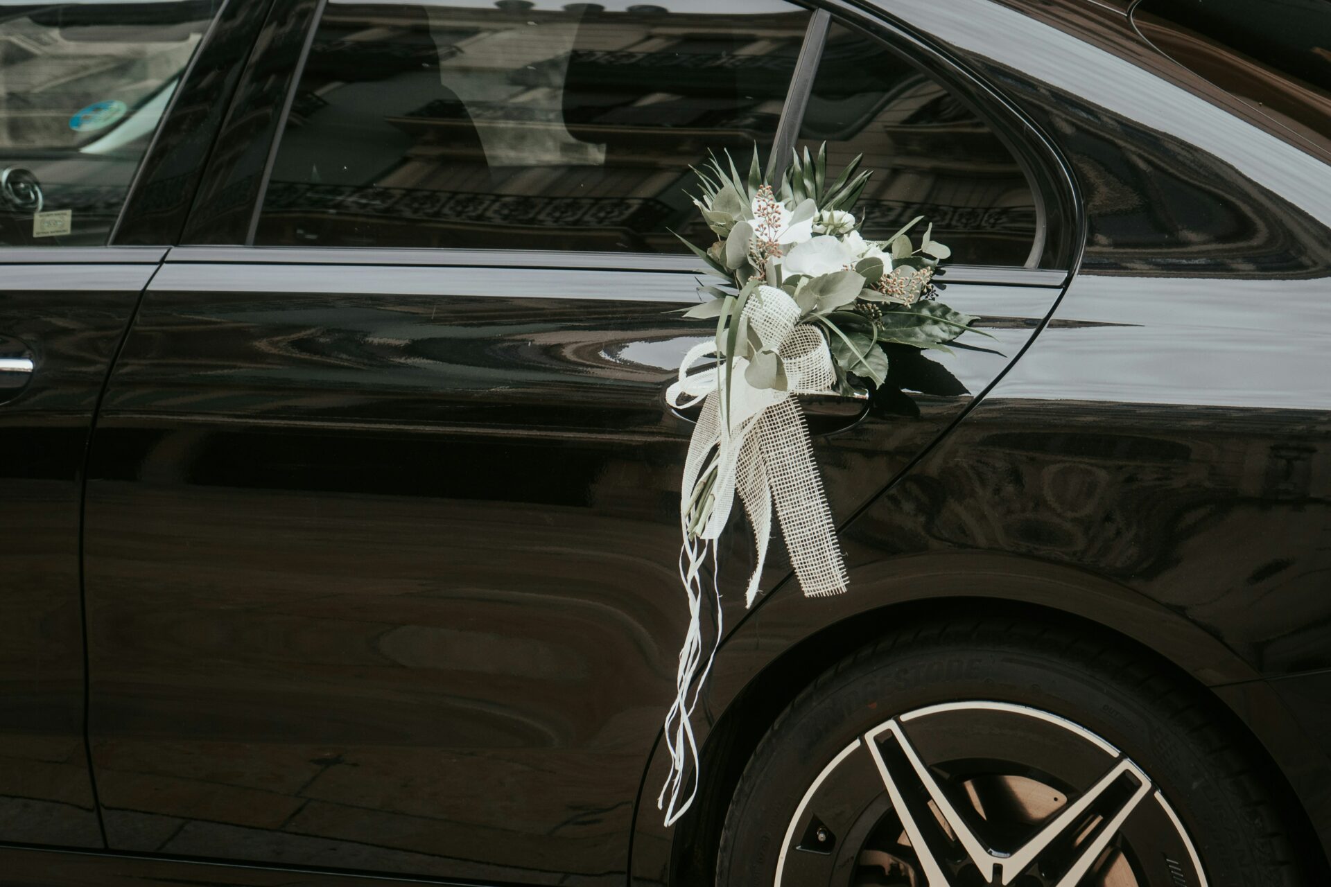 A black wedding limo in NJ with a bouquet tied to the handle